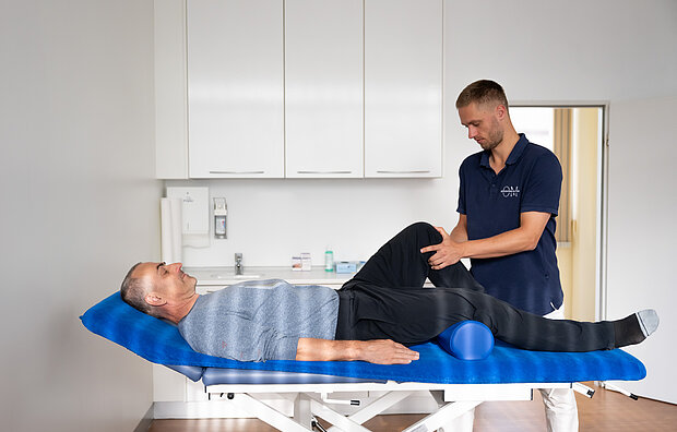 Osteopath untersucht Patienten am Knie