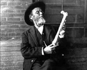 Schwarz-Weiß Fotografie von Andrew Taylor Still, der einen Knochen begutachtet